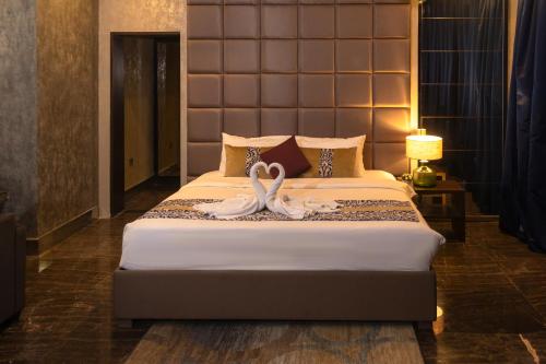 two swans sitting on a bed in a bedroom at Blaire Executive Suites in Manama