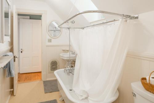Baño blanco con bañera y lavamanos en Parker House, en Camden
