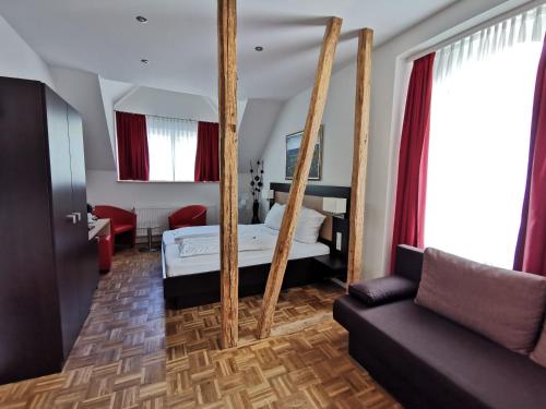 1 dormitorio con espejo, 1 cama y 1 sofá en Altes Pfarrhaus, en Ernst