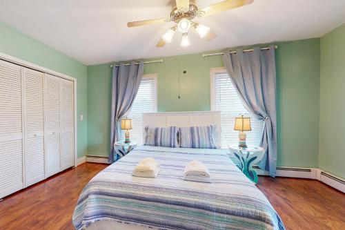 a bedroom with green walls and a bed with two lamps at Written in the Stars in Penn Yan