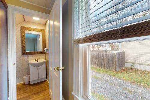 a bathroom with a sink and a mirror and a window at Written in the Stars in Penn Yan