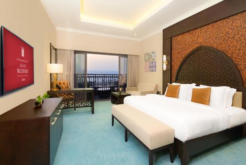 a hotel room with a large bed and a balcony at Grand Millennium Gizan in Jazan