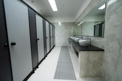 a bathroom with a row of sinks and mirrors at Shelter Beach Resort in Mahabalipuram