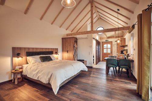 a bedroom with a large bed and a table and chairs at Kittenberger Chalets am Gartensee in Schiltern