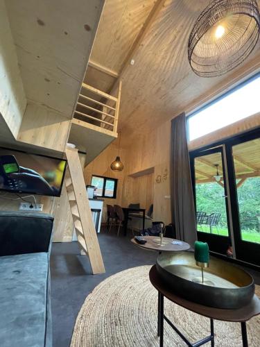 a room with a bed and a staircase and a table at Tiny House am Veluwemeer im Europarcs Bad Hoophuizen in Hulshorst