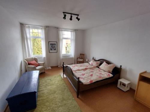 ein Schlafzimmer mit einem Bett, einem Sofa und Fenstern in der Unterkunft Schöne Wohnung, direkt an der Weser, mit Kaminofen in Hessisch Oldendorf