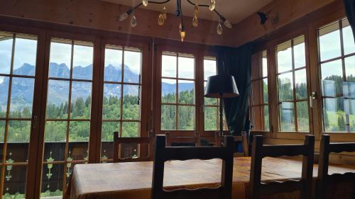 a room with large windows and a table and chairs at Pinson 17 in Champoussin