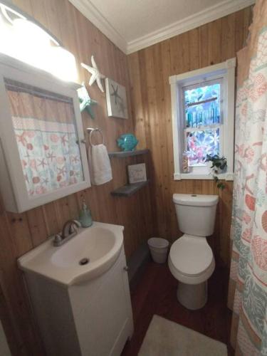a bathroom with a toilet and a sink and a window at Beach House in Pensacola