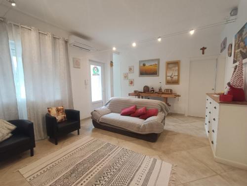een woonkamer met een bank en een stoel bij Il Don Minzoni 98 "Casa Vacanze" in Lido di Camaiore