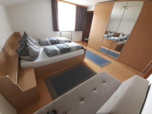 een slaapkamer met een bed en een spiegel bij Haus Früh in Telfes im Stubai