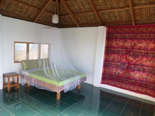 a bedroom with a bed with a mosquito net at Blue Seastar Cottages in Agpudlos