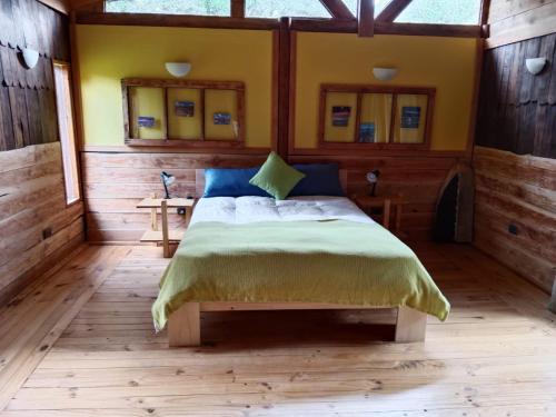 a bedroom with a bed in a wooden room at Casa parcela Frutillar in Frutillar