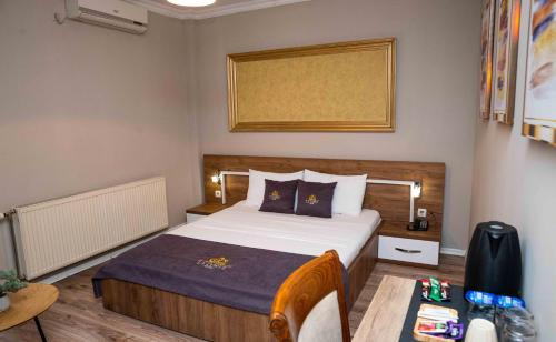 a small bedroom with a bed and a table at Hotel LaCorte Prishtina in Pristina