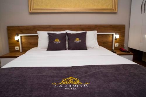 a bed in a hotel room with a king sized bed at Hotel LaCorte Prishtina in Pristina