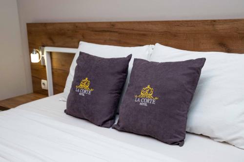 a bed with two pillows with a bed institute on it at Hotel LaCorte Prishtina in Pristina