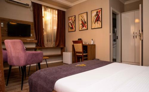 a hotel room with a bed and a table and chairs at Hotel LaCorte Prishtina in Pristina