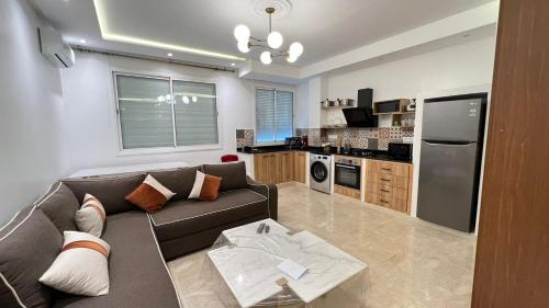 ein Wohnzimmer mit einem Sofa und einer Küche in der Unterkunft Petit nid douillé au coeur de Casablanca in Casablanca