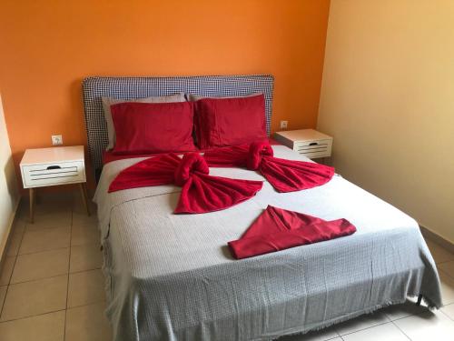 a bed with red pillows and bows on it at Kakovatos - Luxury sea view apartment “Theodora” 54m2. in Kakóvatos