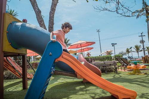 a young boy on a slide at a playground at Hotel VillaReal Guaratuba - Caieiras in Guaratuba