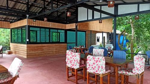 eine Terrasse mit einem Holztisch und Stühlen in der Unterkunft Payam Cabana in Ko Phayam