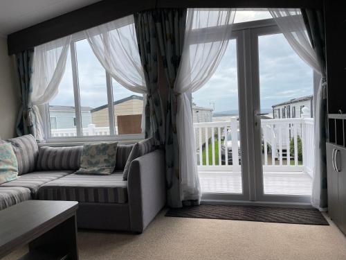 a living room with a couch and a large window at Rockley Park Private Holiday Homes in Poole