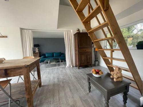 - un salon avec un escalier en bois dans l'établissement L Atelier d Amélie, à Thérouldeville