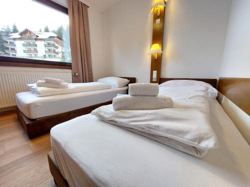 two beds in a room with a window at Bad Kleinkirchheim RMG family apartments in Bad Kleinkirchheim