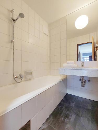 a white bathroom with a tub and a sink at Bad Kleinkirchheim RMG family apartments in Bad Kleinkirchheim