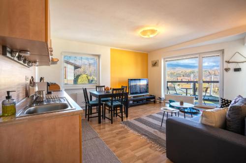 uma cozinha e sala de estar com um sofá e uma mesa em Apartment Romana High Tatras-Fantastic views-Washer em Nová Lesná