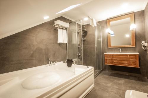 a bathroom with a tub and a sink and a mirror at Zanike hotel in Trabzon