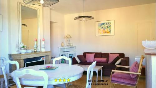 een woonkamer met een bank en een tafel en stoelen bij Charme Le Cadran Solaire classé 4* in Sancey-le-Long