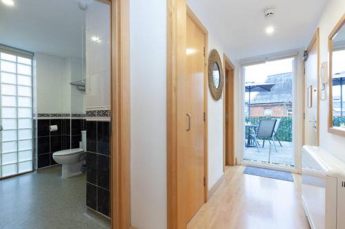 a bathroom with a toilet and a glass door at Apartment in the heart of the city centre, live like a local in Oxford
