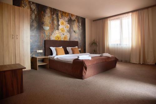 a bedroom with a bed and a wall with flowers at Flamingo Plovdiv in Plovdiv