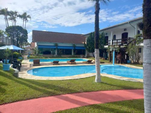 a swimming pool in front of a house at Pousada Believe in Praia Grande
