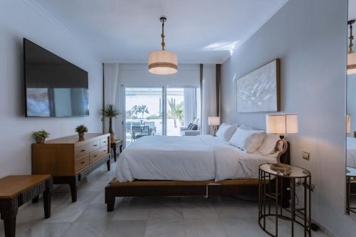 a large bedroom with a large bed and a desk at Molo Bahia Apartment Near the beach in Marbella