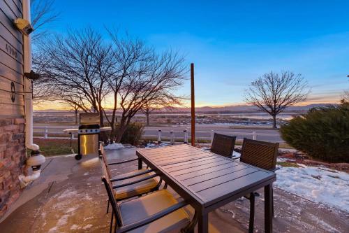 a wooden table and chairs on a patio with a grill at Family-friendly Home on Boyd Lake, Gorgeous Views! in Loveland