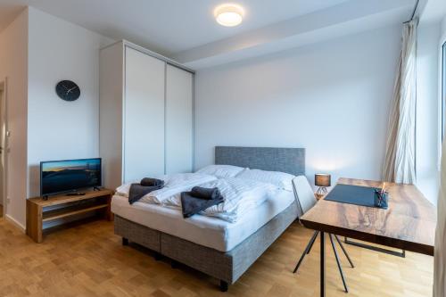 um quarto com uma cama, uma televisão e uma mesa em Handmade I Modern I Luxury I Kitchen I Home Office I Netflix em Holzgerlingen