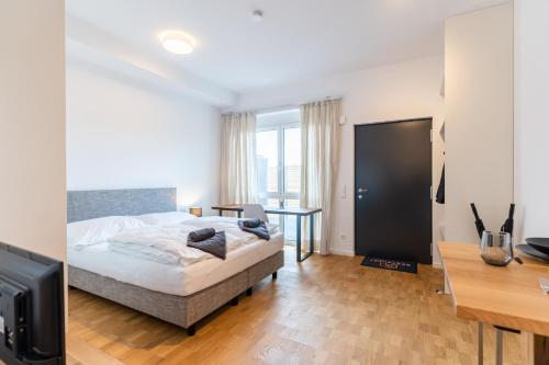 1 dormitorio con 1 cama, escritorio y TV en Handmade I Modern I Luxury I Kitchen I Home Office I Netflix, en Holzgerlingen