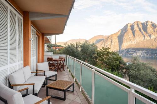 a balcony with chairs and tables and a view of a mountain at Happy Guest Apartments - Blue Apartment in Riva di Solto