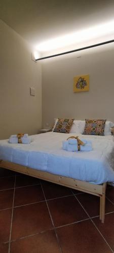a bedroom with a large bed with two towels on it at Casale Di Benedetto in Caltagirone