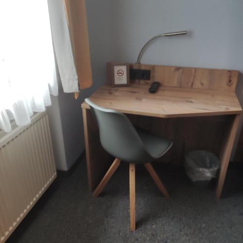 a wooden desk with a chair and a lamp on it at Gasthof Goldene Krone in Selbitz