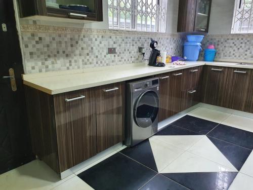 a kitchen with a washing machine in a kitchen at Villa Nelomoor in Kwabenya