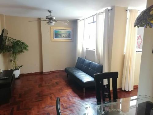 Una sala de estar con un sofá y una mesa de cristal. en Hospedaje Las Lilas Surco, en Lima