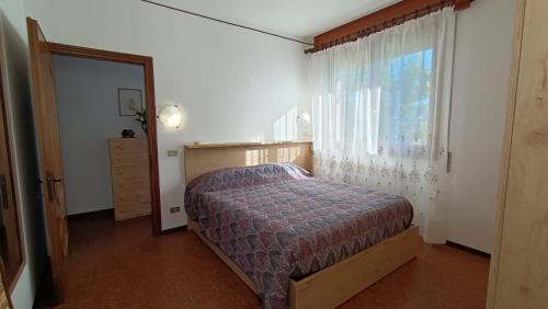 1 dormitorio con cama y ventana en Apartment with garden, lake view and parking - Larihome A15, en Domaso