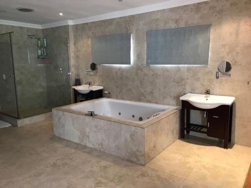 a large bathroom with a tub and a sink at Bird's View in Hermanus