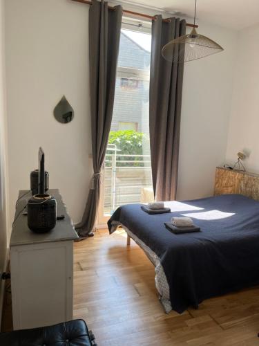 une chambre avec un lit et un bureau avec une fenêtre dans l'établissement Ravissant loft avec parking souterrain gratuit sur place, à Ivry-sur-Seine