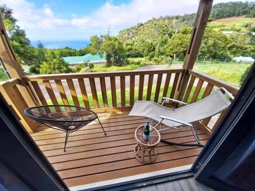 a wooden deck with a chair and a table and a table at Banana Tree Lodge in Jamestown