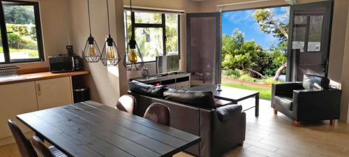 a living room with couches and a table and chairs at Banana Tree Lodge in Jamestown