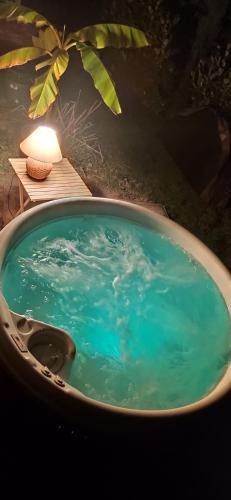 une baignoire remplie d'eau bleue à côté d'une table dans l'établissement Domaine Le Haut-Vent, à Fosses-La-Ville