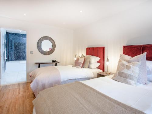 a bedroom with two beds and a mirror at Primrose-uk34614 in Nether Stowey
